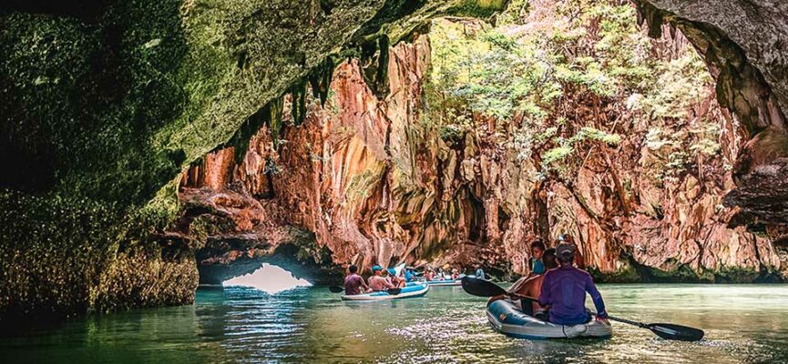 Kayak entering a sea cave with light streaming in