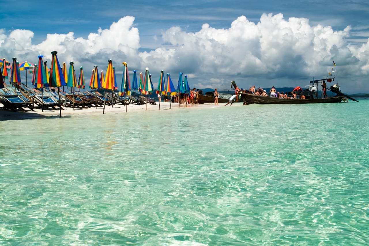 Small sandy island with boats anchored nearby like the Khai Islands
