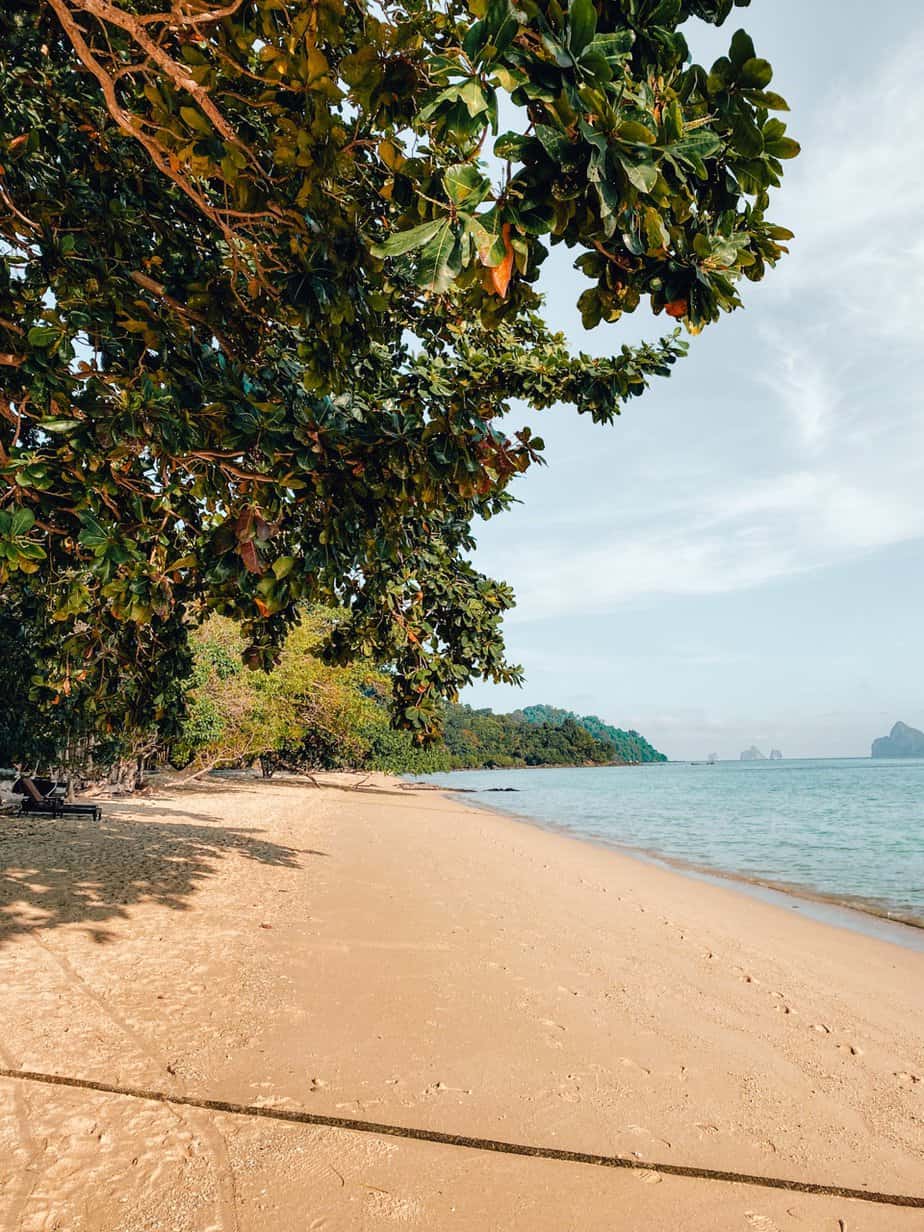 Tropical beach with longtail boat on clear water like Koh Kradan