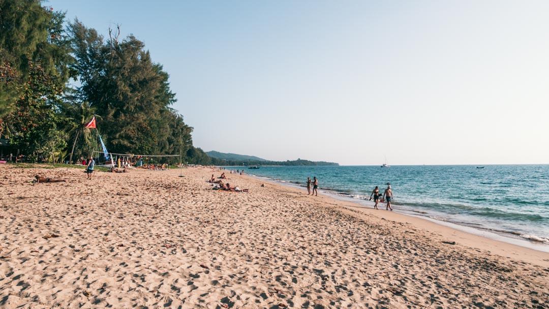 Relaxed beach scene at Koh Lanta with palm trees and soft sand
